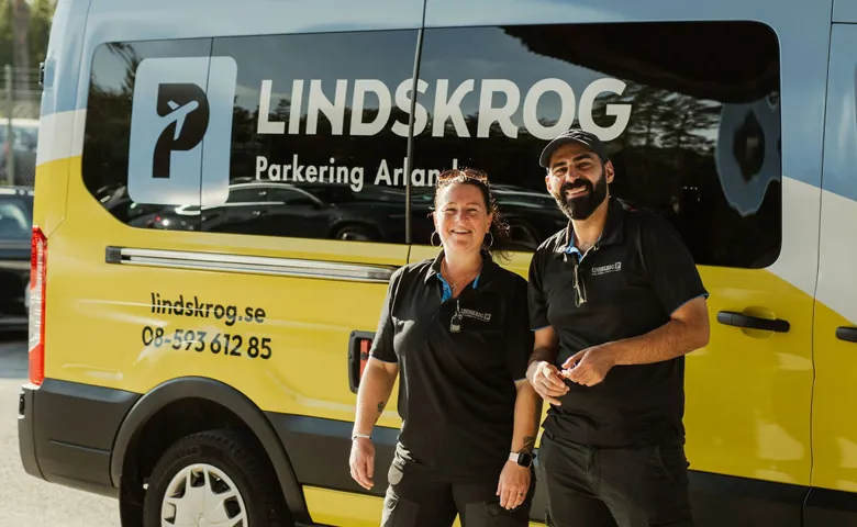 Trevlig personal framför en transferbuss märkt ”Lindskrog Parkering Arlanda”.