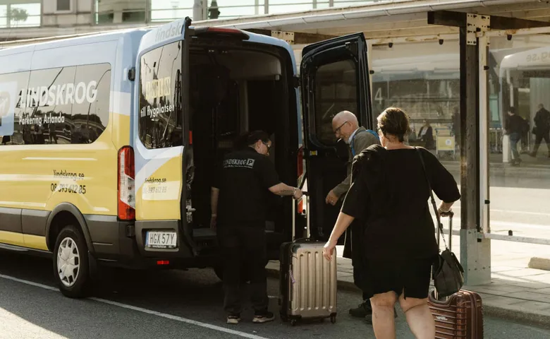 En av Lindskrogs chaufförer hjälper resenärerna med bagaget efter gratis transfer till terminalen på Arlanda.