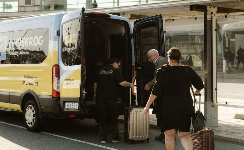 En av Lindskrogs chaufförer hjälper resenärerna med bagaget efter gratis transfer till terminalen på Arlanda.